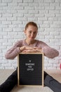 Young woman sitting behind the felt letter board with the words Someone You Loved Royalty Free Stock Photo