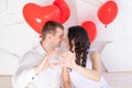 Valentine`s day, a couple in love shows a heart from their hands and looks at each other with a loving look Royalty Free Stock Photo