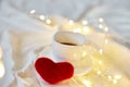 Valentine\'s Day Cup of coffee in bed with a red hearts and lights, copy space