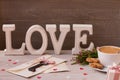 Valentine`s day decoration close up. Cup of coffee, gifts, flowers and word love on wooden background. Key from your heart.