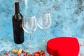 Valentine`s Day February 14 or fourteen elements on blue background: Red wine bottle, two wine glass, red heart shaped box gi Royalty Free Stock Photo