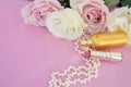 Valentine`s Day. Female accessories, jewelry, perfume bottle, gift with ribbon , pearls, gentle roses on a pink background. Royalty Free Stock Photo