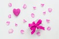 Valentine`s day, festive composition. Purple heart, purple rose petals and a gift box with purple ribbon. White wooden background Royalty Free Stock Photo