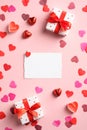 Valentine`s Day flat lay composition. Top view blank paper card, gifts, hearts on pink table. Valentines day greeting card mockup Royalty Free Stock Photo