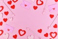Valentine`s day flat lay with love letters, cupid arrows and red heart confetti forming border Royalty Free Stock Photo