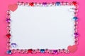 Valentine`s day frame on pink background made of pebbles in the shape of a heart with white space and paper hearts. Royalty Free Stock Photo