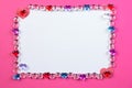 Valentine`s day frame on pink background made of pebbles in the shape of a heart with white space and paper hearts. Royalty Free Stock Photo