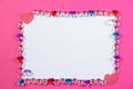 Valentine`s day frame on pink background made of pebbles in the shape of a heart with white space and paper hearts. Royalty Free Stock Photo