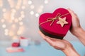 Valentine`s Day gifts in heart shaped box in hands, bokeh Royalty Free Stock Photo