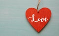 Valentine`s Day greeting card.Decorative red heart with text Love on a blue wooden background.February 14 concept. Royalty Free Stock Photo