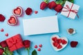 Valentine\'s day greeting card mock up with heart shape chocolate, gift box and rose flowers on blue background. Royalty Free Stock Photo