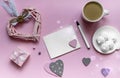 Valentine`s day greeting card. Pink light pastel background. Cup of coffee and marshmallows, heart shaped decoration. Flat lay, Royalty Free Stock Photo