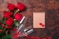 Valentine`s day greeting card with red rose flowers and champagne glasses on wooden background Copy space Top view Royalty Free Stock Photo