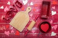 Valentine\'s Day greeting card. Word LOVE. rolling pins, and cookie cutters, on a red wooden background. Royalty Free Stock Photo