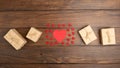 Little red wooden crafted hearts and gift boxes on the wooden background. Valentines greeting