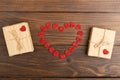 Valentine's Day greetings concept. Little red wooden crafted hearts and gift boxes on the wooden background.