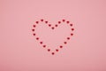 Valentine`s Day heart shape made of small red hearts on a pink background Royalty Free Stock Photo