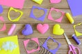 Valentine`s day hearts crafts. Colorful hearts gifts made of felt, felt scraps, scissors, thread on wooden table