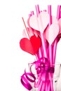 Valentine`s day holiday. bright pink drinking straws with hearts and a pink ribbon in a glass isolated on white Royalty Free Stock Photo