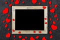 Valentine`s Day. Layout for the postcard. Wooden frame blank and hearts on a black stone background, copy space Royalty Free Stock Photo