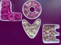 Valentine's day and love concept. The word love is made up of white porcelain molds filled with rosebuds on a dark Royalty Free Stock Photo