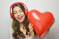 Valentine`s day love girl concept. Cute enthusiast girl with red headphone listening to the music of his heart. Young happy woman Royalty Free Stock Photo