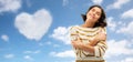 Woman hugging herself over heart shaped cloud