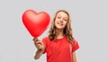 Smiling teenage girl with red heart shaped balloon Royalty Free Stock Photo