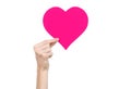 Valentine's Day and love theme: hand holding a pink heart isolated on a white background
