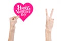 Valentine's Day and love theme: hand holds a greeting card in the form of a pink heart with the words Happy Valentine's day Royalty Free Stock Photo