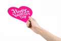 Valentine's Day and love theme: hand holds a greeting card in the form of a pink heart with the words Happy Valentine's day Royalty Free Stock Photo