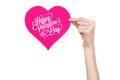 Valentine's Day and love theme: hand holds a greeting card in the form of a pink heart with the words Happy Valentine's day Royalty Free Stock Photo