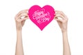 Valentine's Day and love theme: hand holds a greeting card in the form of a pink heart with the words Happy Valentine's day Royalty Free Stock Photo