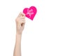 Valentine's Day and love theme: hand holds a greeting card in the form of a pink heart with the words Love you isolated Royalty Free Stock Photo