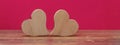 Valentine`s Day Love wedding banner greeting card template - two wood hearts on rustic wooden table and pink background texture Royalty Free Stock Photo