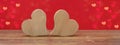 Valentine`s Day Love wedding banner greeting card template - two wood hearts on rustic wooden table and red background texture Royalty Free Stock Photo