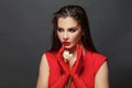Valentine`s Day. Loving woman. Beautiful female model in a red dress on black. Red lipstick makeup