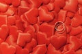 Valentine`s day many red silk hearts background with two gold rings, love concept Royalty Free Stock Photo