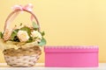 Valentine\'s day, mother\'s day, birthday. Flowers in a basket and a pink box with a gift on the table. still life space