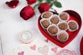 Valentine`s day. Nutty chocolate in a red heart box and red roses for Valentine`s or anniversary present. Soft focus on the nutt Royalty Free Stock Photo