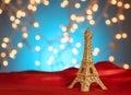 Valentine`s Day in Paris. Christmas, New Year in Paris. Golden Eiffel Tower on bright red satin. Blurred Xmas lights background. Royalty Free Stock Photo