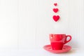 Valentine`s Day with red cup coffee Sewed pillow hearts row border, wood white background Royalty Free Stock Photo