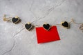 On Valentine's Day, a red sheet of paper hangs on a string of pins with black hearts on a gray background to