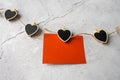 On Valentine's Day, a red sheet of paper hangs on a string of pins with black hearts on a gray background to