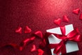 Valentine`s Day Romantic Background with gift box and satin hearts. Date. Table setting with gift box over holiday red background Royalty Free Stock Photo