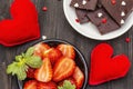 Valentine`s Day romantic concept. Chocolate, fresh ripe strawberry, red felt hearts. Sweet dessert for lovers. Black wooden