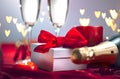 Valentine`s Day romantic dinner. Champagne, candles and gift box over holiday background