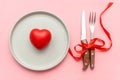 Valentine\'s Day romantic dinner dating love concept. tabble serving with cutlery and heart decor on pink background.