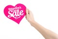 Valentine's Day and sale topic: Hand holding a card in the form of a pink heart with the word Sale isolated on white background Royalty Free Stock Photo