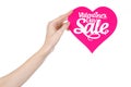 Valentine's Day and sale topic: Hand holding a card in the form of a pink heart with the word Sale isolated on white background Royalty Free Stock Photo